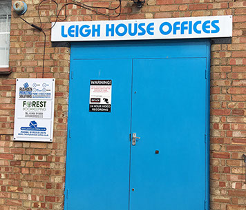 Doorway showing overhead sign and one to the left supplied and installed by Luxe Graphics, Desborough Sign company